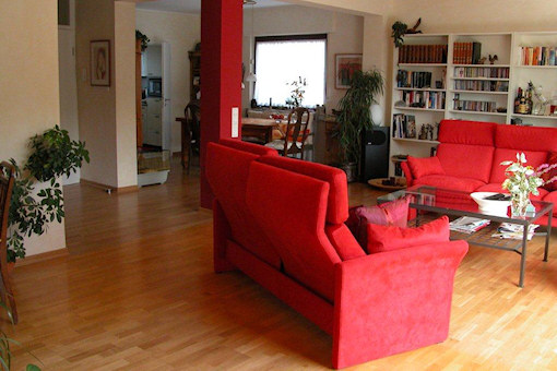 Nach der Sanierung: Offenes Wohnzimmer mit roten Farbakzenten