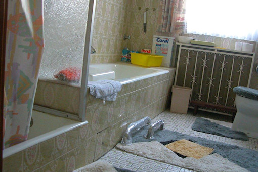 Vor dem Umbau: In die Jahre gekommenes Badezimmer mit Badewanne und Dusche