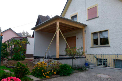 Während des Anbaus: Ein Holzkonstrukt mit Überdachung als Grundgerüst für den Wintergarten
