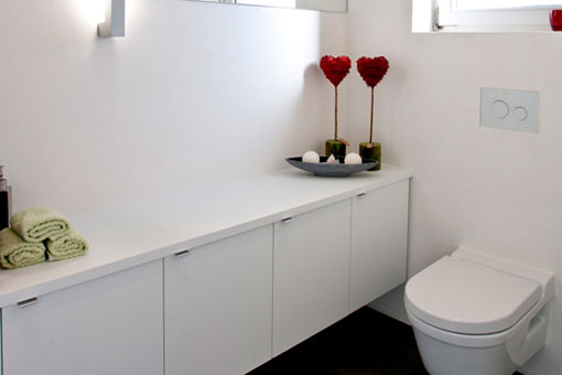 Nach dem Umbau: Weiße Hängeschränke sorgen für genügend Stauraum auf der gesamten Länge des WC
