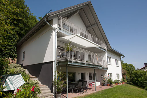 weißes Haus mit Balkon nach Umbau - realisiert durch Zimmerei Josef Zachmeier Dipl-Ing Univ - Einer.Alles.Sauber.