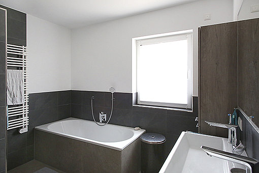 Nach der Aufstockung: Modernes dunkles Badezimmer als Wellnessoase