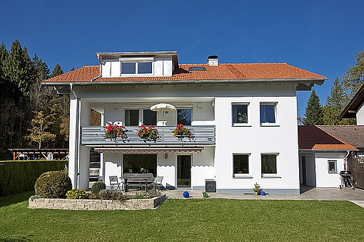 Die Rückansicht des Hauses mit dem neu gestalteten Balkon und integrierten Dachgaube