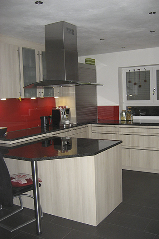 Die Küche mit exklusiven Einbaugeräten und einer schwarzen modernen Arbeitsplatte