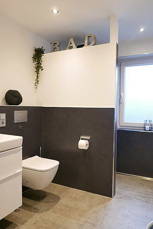 Nach der Sanierung: helles modernes Badezimmer in schwarz-weiß gehalten