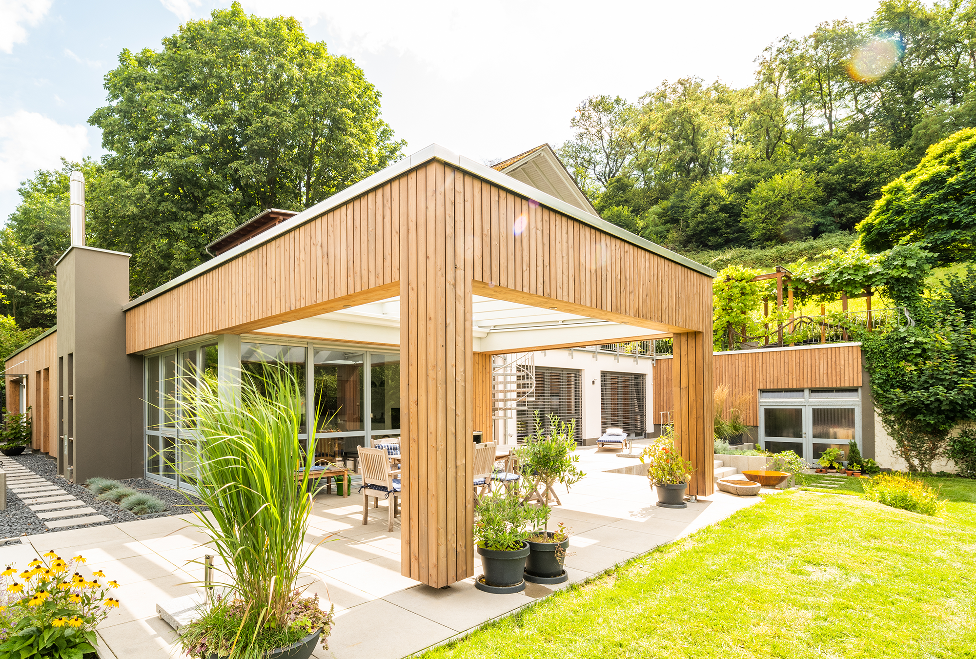 Anbau mit moderner Holzfassade für zusätzlichen Wohnraum und überdachte Terrasse